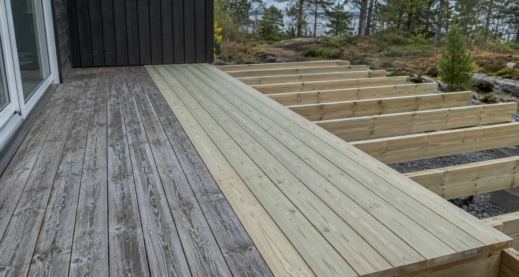 A wooden deck being expanded with new framing and new deck boards